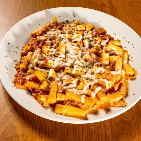 Baked ziti pasta with melted cheese and red sauce on a white plate.
